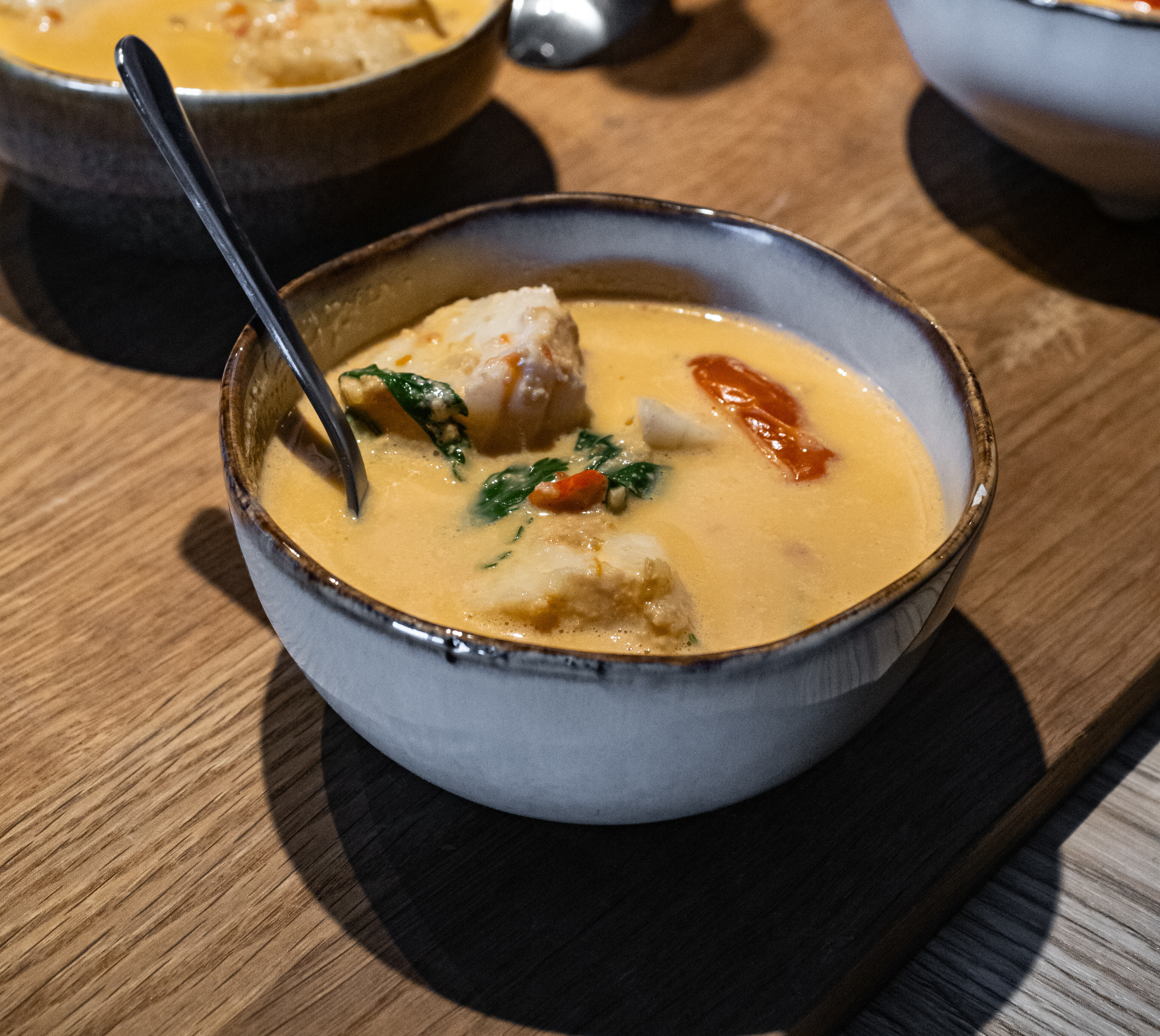 En skål med torske- og krabbesuppe med tomater og chili 